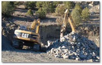 At a company site in Pichoricks Canyon, excavators break up rock to place as riprap for Pioneer Natural Resources.