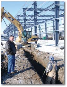 Jones discusses a pipe-laying project with his son, Travis.