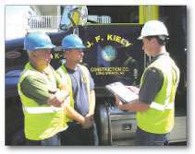 Intern Kevin Gorr conducts a toolbox talk on recognizing the signs of heat exhaustion and heatstroke with utility worker Arthur Capana, left, and foreman Jason Afanador, center, on a jobsite in Bradley Beach, New Jersey.
