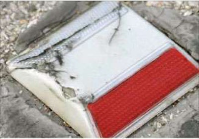 Damage to shell of retro-refective raised pavement marker could be caused by something as simple as a stone wedged in tire tread.