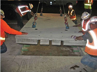 Precast concrete pavement slab is lowered into Utah’s I-15 between Clearfield and Layton.