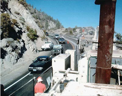 In tight quarters in the Pacific Northwest, a cold-in-place recycling train of Valentine Surfacing climbs a mountain grade.