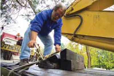 Use a cargo strap to secure blocking during an excavator transport.