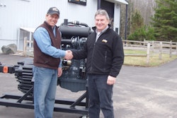 Jon Sowl (left), instructor at Northeast Wisconsin Technical College, accepts donation of Case engine from Russ Wadzinski, general manager of Case Customer Center, Tomahawk, Wis.