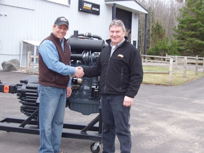 Jon Sowl (left), instructor at Northeast Wisconsin Technical College, accepts donation of Case engine from Russ Wadzinski, general manager of Case Customer Center, Tomahawk, Wis.