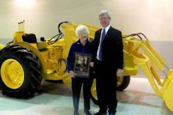 Sue Long, widow of Elton Long, and Sandy Mill, Long's son-in-law, display a replica plaque honoring Long's induction.