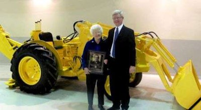Sue Long, widow of Elton Long, and Sandy Mill, Long's son-in-law, display a replica plaque honoring Long's induction.