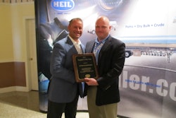 Greg Hewitt, President of Heil Trailer International, presents the Supplier of the Year award to Mike Baird of Alcoa Wheel.