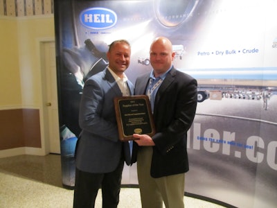 Greg Hewitt, President of Heil Trailer International, presents the Supplier of the Year award to Mike Baird of Alcoa Wheel.