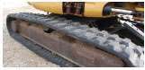TRACKS — Anchor the machine with the bucket on one side, and tilt it up. Then run the track on the elevated side, looking for cuts, missing chunks or dry rot in the rubber. Repeat on the other side.