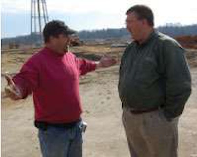 While waiting for the trucks to arrive Cosper discusses a job with paving foreman Todd Hemphill.