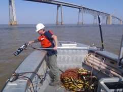 Engineer deploying sonar from side of boat