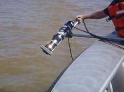 Close-up of engineer deploying sonar from side of boat