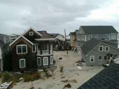 This is the collapsed home (in the photo’s center) along the New Jersey shore of the mother of a Randall-Reilly Construction Media Division’s friend. Better Roads is part of this division.