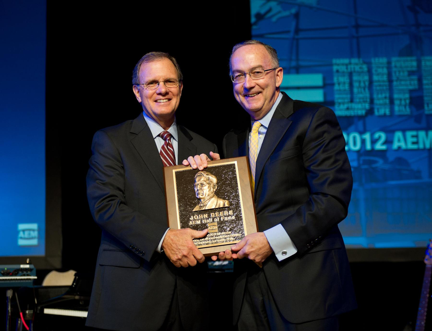 Deere & Company Chairman and Chief Executive Officer, Sam Allen accepts the AEM Hall of Fame plaque from 2012 Chair of the AEM and CEO of Krone, North America, Rusty Fowler