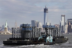 The spire of One World Trade Center approaches New York Harbor with the New York skyline in the background. (AP Photo/Mark Lennihan)