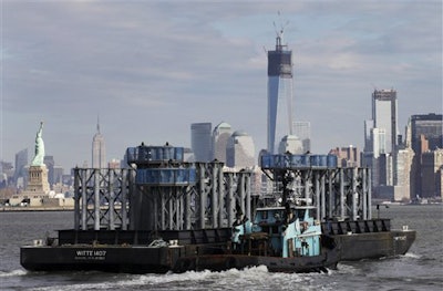 The spire of One World Trade Center approaches New York Harbor with the New York skyline in the background. (AP Photo/Mark Lennihan)
