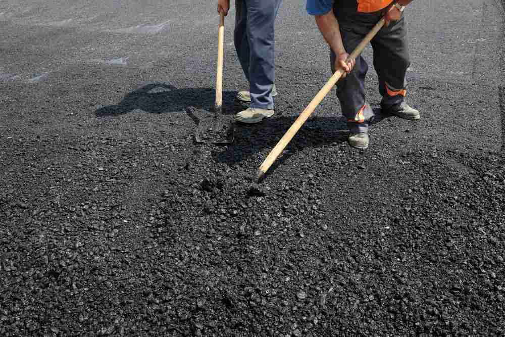 workers shoveling asphalt stock