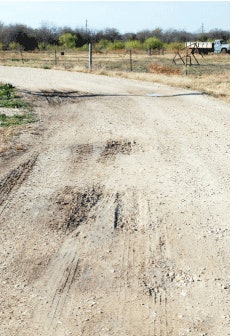 Poor drainage results in ponding and aggregate loss in unpaved roads.