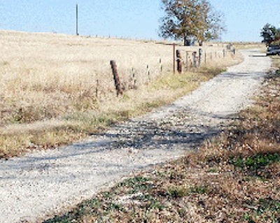 A clogged corrugated drainpipe under this Texas road results in water flowing across it, eroding the surface and creating a ford in wet weather.