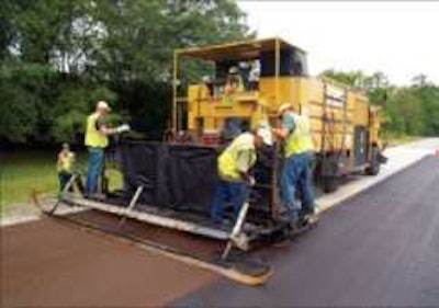 The new NCAT Pavement Test Track life cycle pavement preservation performance study also will include data from an instrumented local road near the track, the traffic of which is almost entirely truck traffic to and from a quarry; here in late summer, micro surfacing is placed as part of NCAT study
