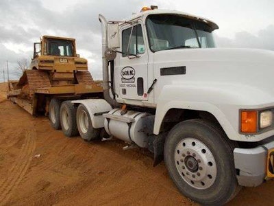 A Caterpillar D6R sits on a trailer bed of a Racon, Inc. truck. The equipment is part of the company’s $26 million auction.