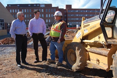 Mitch Cox (left) discusses a sitework with Raymond McBride, president of Mitch Cox Construction and Scotty Lane, senior superintendent.