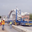 Workers guide in one of the precast arches of Fort Worth’s new West 7th Street bridge. Each arch is 163.5 feet long.