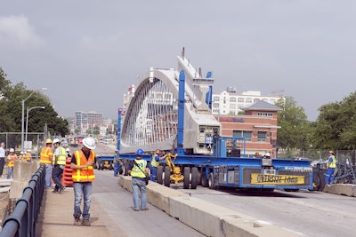 Workers guide in one of the precast arches of Fort Worth’s new West 7th Street bridge. Each arch is 163.5 feet long.