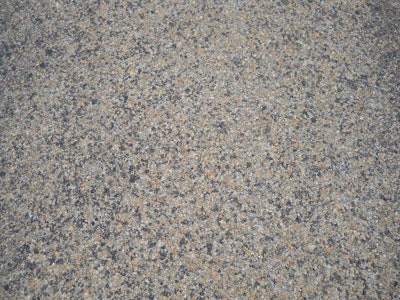 A close-up shows the highway’s three-course surface treatment that included the use of CRS-2P, a cationic rapid setting type of emulsified asphalt modified with the addition of polymers, and expanded clay lightweight aggregate. (Photo: Big River Industries)