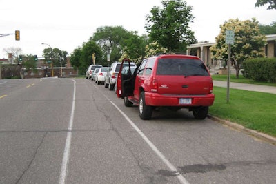 A vehicle opens its door into the bike lane. (Photo: Mike Juvrud / Flickr)