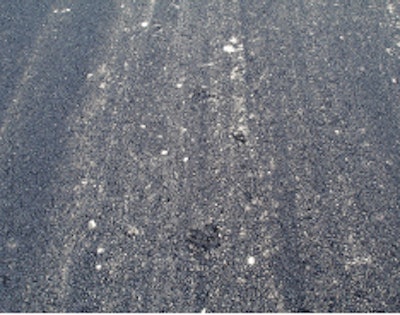 Too much force and excessive rolling caused severe damage to aggregates and the surface of this asphalt layer.