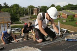 Jonathan Silke cuts shingles on a roof in Des Moines. Credit: Bryon Houlgrave/The Des Moines Register