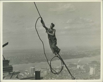 Worker clings to a wire during construction of the Empire State Building. Credit: Lewis Wickes Hine
