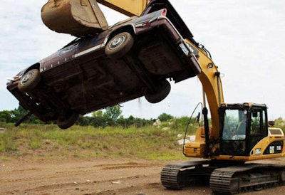 A patron of Extreme Sandbox smashes a car with an excavator. Credit: Jennifer Simonson/MPR