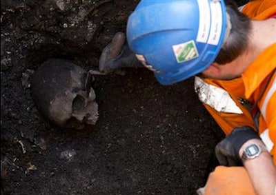 An archaeologist uncovers a skull as construction continues on London’s Crossrail commuter line. Credit: Alastair Grant/AP