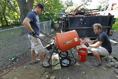 Dan Wheeler, left, and Zach Weinkauf pour concrete for a deck installation. Credit: Elizabeth Flores/Star Tribune