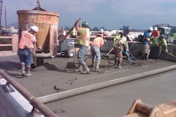 Crews smooth out concrete as a crane uses a bucket to pour the material. (Photo: WSDOT)