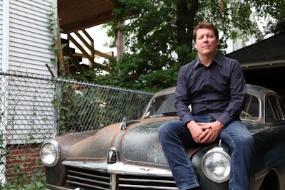 Dan McNichol sits on the 1949 Hudson he will drive during the tour.