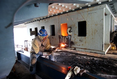 A man works on temporary bearings on shearkey. (Photo: Caltrans)