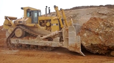 Caterpillar D11R pushing a rock