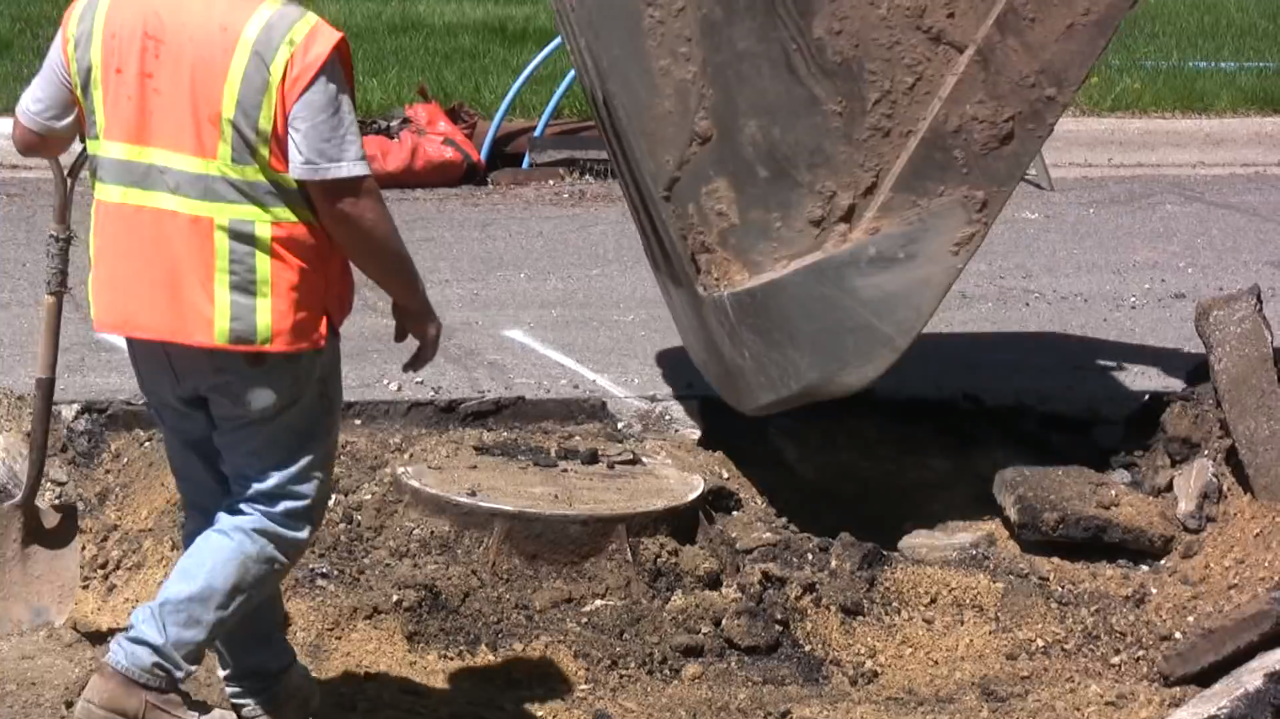 Excavator exposes manhole with surgical precision