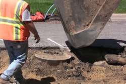 Excavator exposes manhole with surgical precision