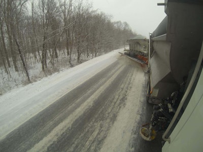 A view looking back at the tow plow, a trailer that attached to the back of a tandem plow truck, which was plowing two lanes in one pass along I-76 in Portage County. The tow plow has a massive 22-foot plow, 7-ton salt hopper and 250-gallon brine tank. The large size of this one truck allows it do the work of two trucks by being able to plow both lanes in one pass. This is one of three tow plows in the ODOT, all of which are used in District 4. (Photo by Brent Kovacs)