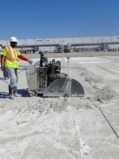 The slurry is swept to the edge of the perimeter of the work area, where it begins to solidify, while sawcutting continues.