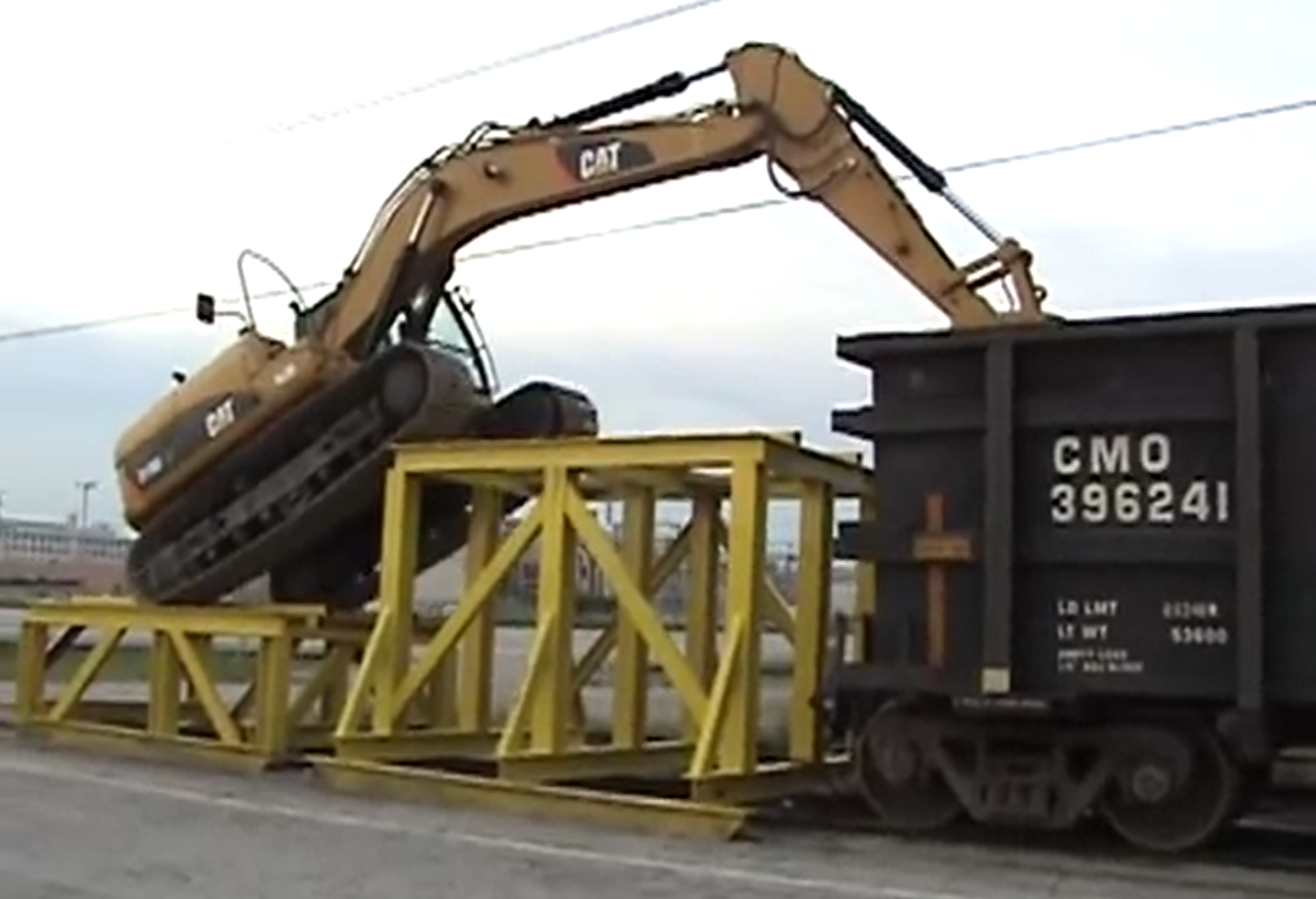 Caterpillar D319 climibing into a railcar