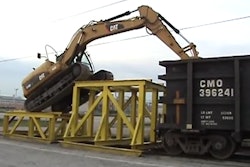 Caterpillar D319 climibing into a railcar