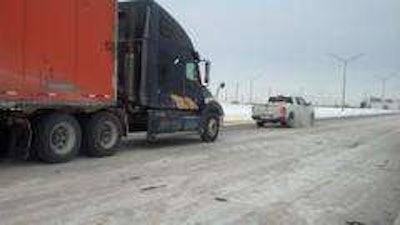 Indiana State Police help a truck stuck on the Interstate. Police and Indiana Department of Transportation crews had to shovel sand under truck tires to help them gain traction.