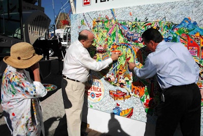 Terex Chairman and CEO Ron DeFeo and AEM President Dennis Slater add their fingerprints to the “I Make America” painting. (Photo courtesy of Terex)