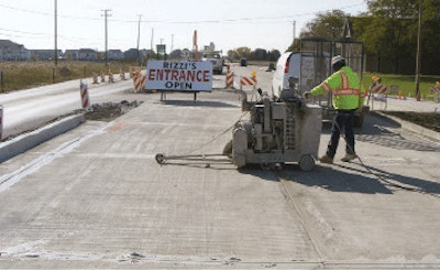Diamond blade wet sawing widens and washes transverse crack control joints prior to sealing.